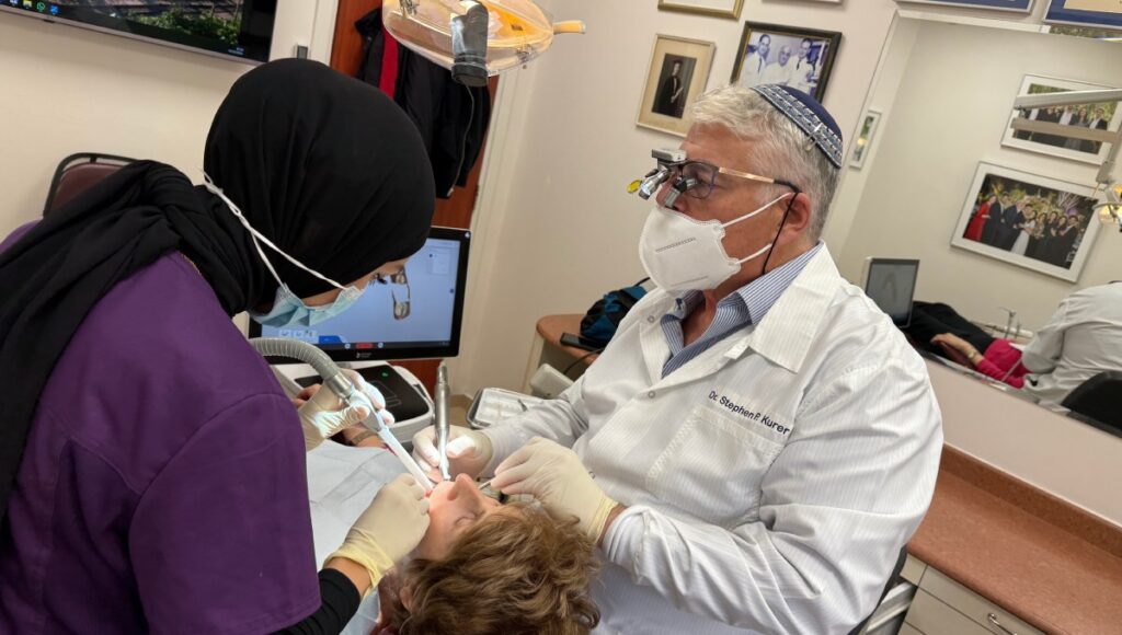 Dr. Stephen Kurer and an assistant treating a patient at the clinic